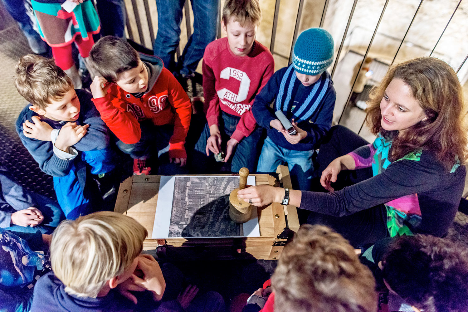 Kinder sitzen im Kreis und hören dem Guide zu